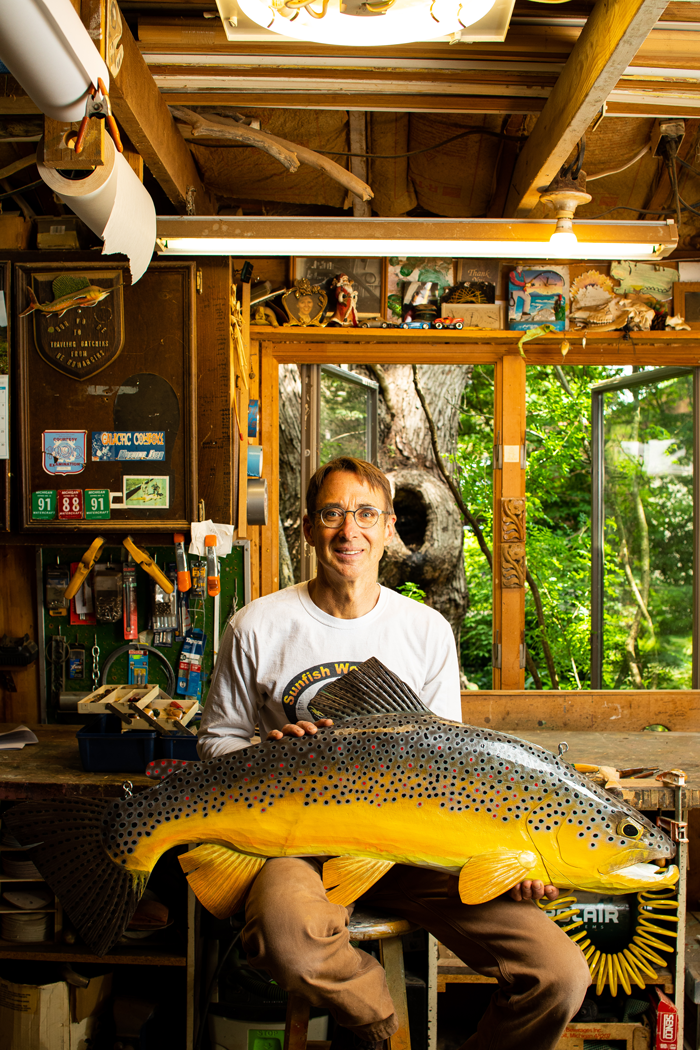 Bob Batchik sits with large brown trout carving