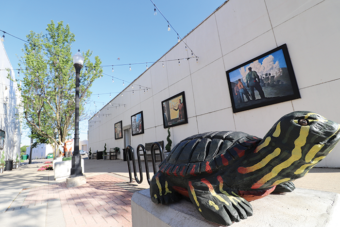 A painted turtle sculpture greets shoppers in an art-filled alley. The area is part of the city’s thriving art scene. 